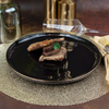 Assiette de restaurant noire en céramique avec bord doré 