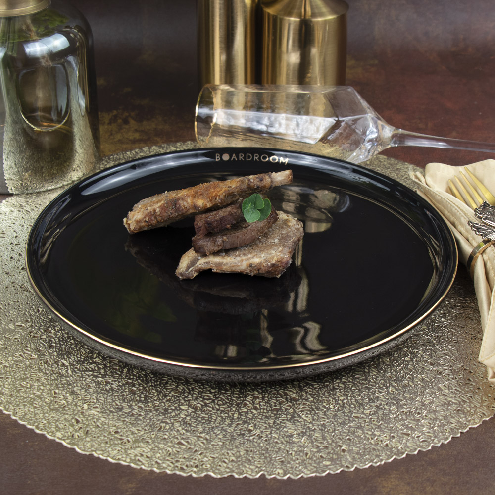 Assiette de restaurant noire en céramique avec bord doré 