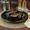 Assiette de restaurant noire en céramique avec bord doré 