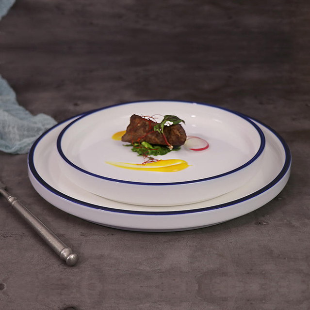Assiette d'hôtel en porcelaine avec bord bleu